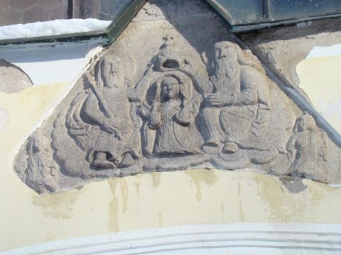 nad hlavním vchodem je reliéf Korunování Panny Marie
