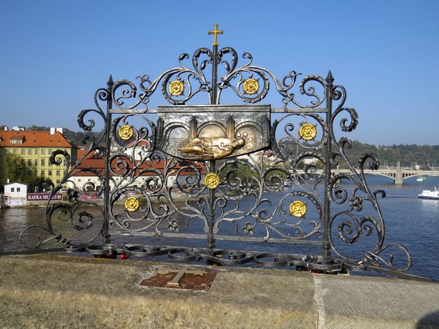 kovaná mříž s reliéfem Svržení Jana Nepomuckého na Karlově mostě