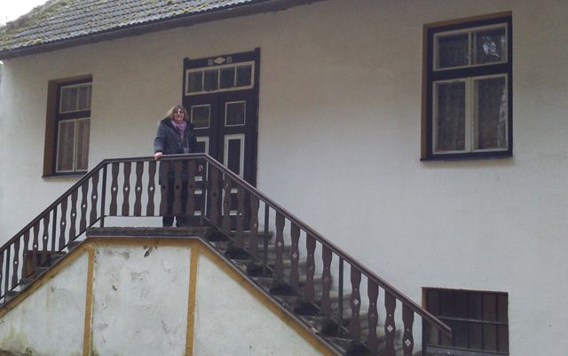 paní Lidmila Anna Dohnalová přede dveřmi bytu, kde strávila prvních dvacet let života (levé okno je z Vodičkovy kuchyně); foto Silva Poukarová