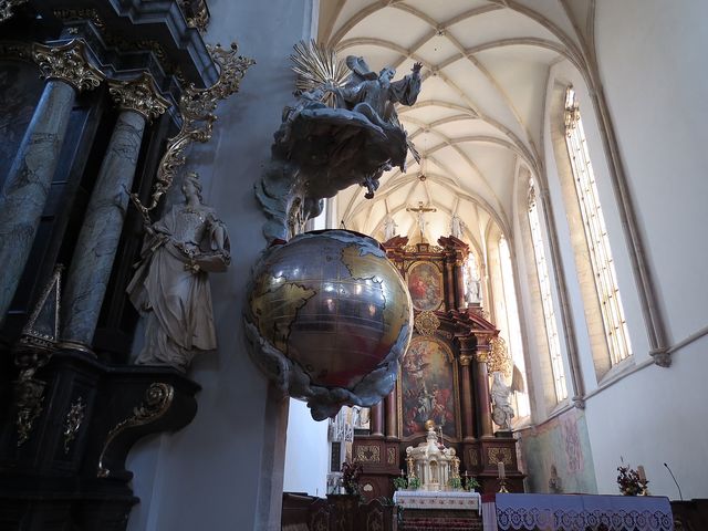 barokní kazatelna v podobě zeměkoule a síťová klenba kostela