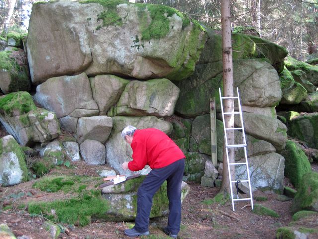 Mirek připevňuje informační tabulku na dřevěnou podložku Mirek připevňuje informační tabulku na dřevěnou podložku