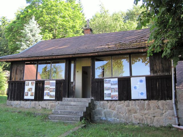 na stěně malé chaty z roku 1913 je výstava z činnosti odboru KČT Čeřínek
